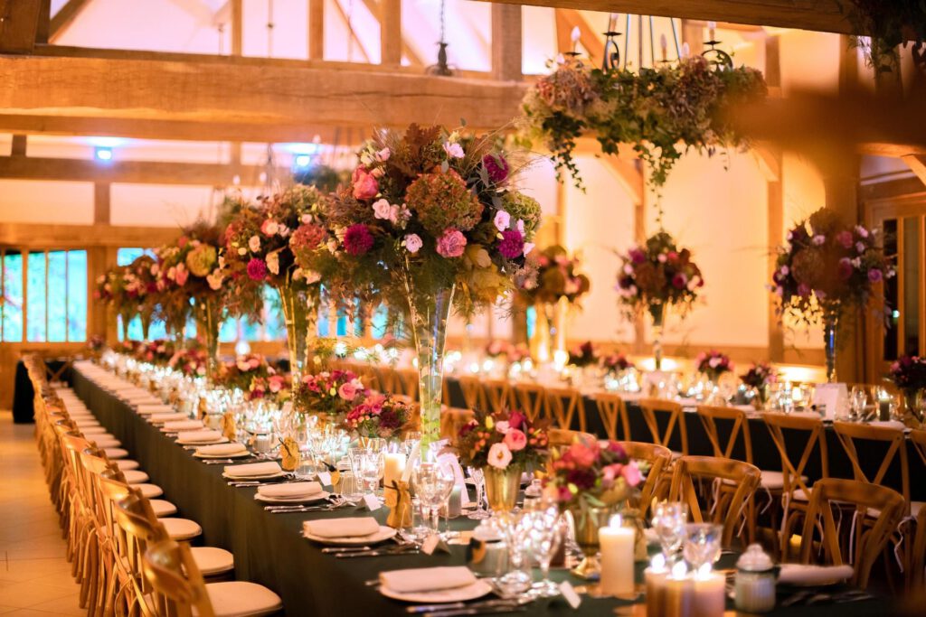 Tables élégamment dressées avec des compositions florales pour un événement au Pressoir de Tourgéville en Normandie.